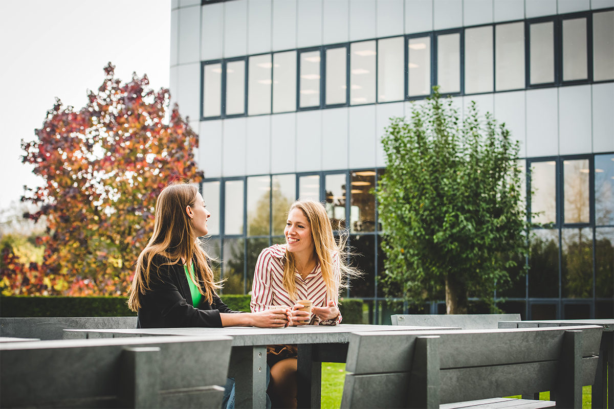 AholdDelhaize_Careers_Delhaize Belgium_Valerie Fabri_Supply Chain_talking_to_colleague_outside_sitting (1).jpg